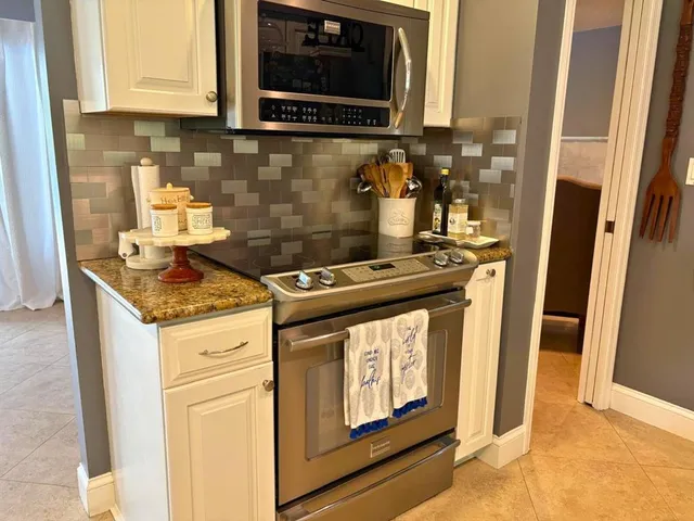a kitchen with stainless steel appliances granite countertop a stove and a microwave
