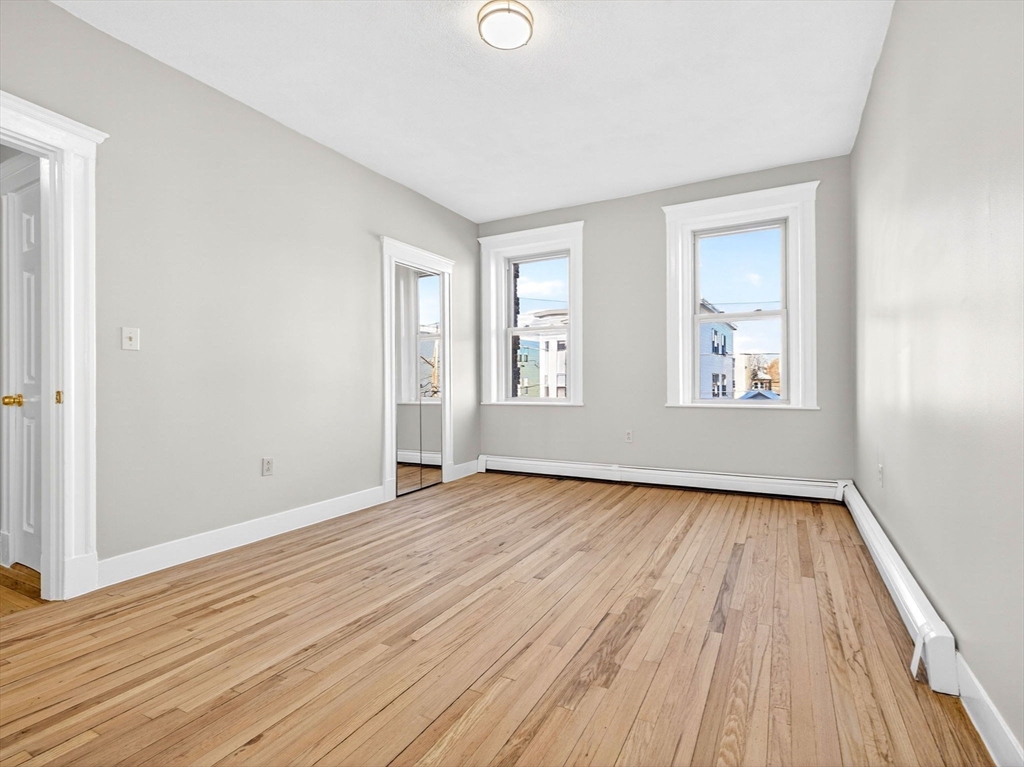 12 Ransom Road, Unit 7 Boston, MA 02135 - Photo 2 of 4 an empty room with wooden floor and windows