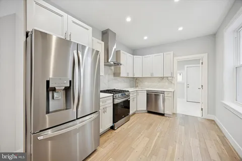 a kitchen with stainless steel appliances a refrigerator sink and cabinets