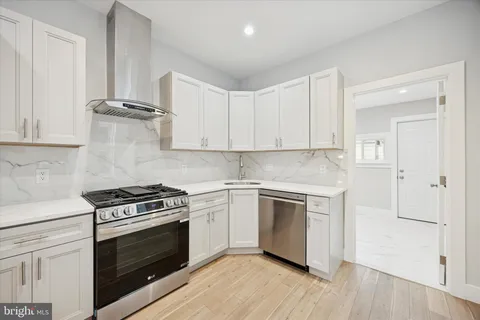 a kitchen with cabinets appliances and wooden floor