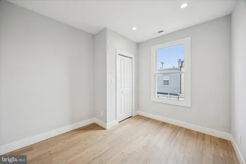 an empty room with a hardwood and hallway