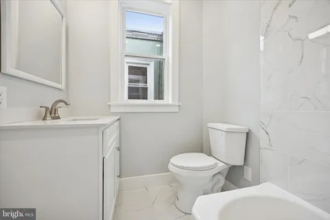 a white toilet sitting next to a bathroom sink