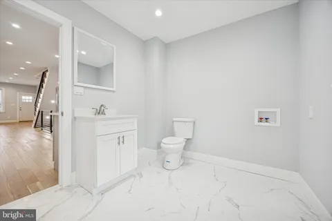 a spacious bathroom with a toilet sink and mirror