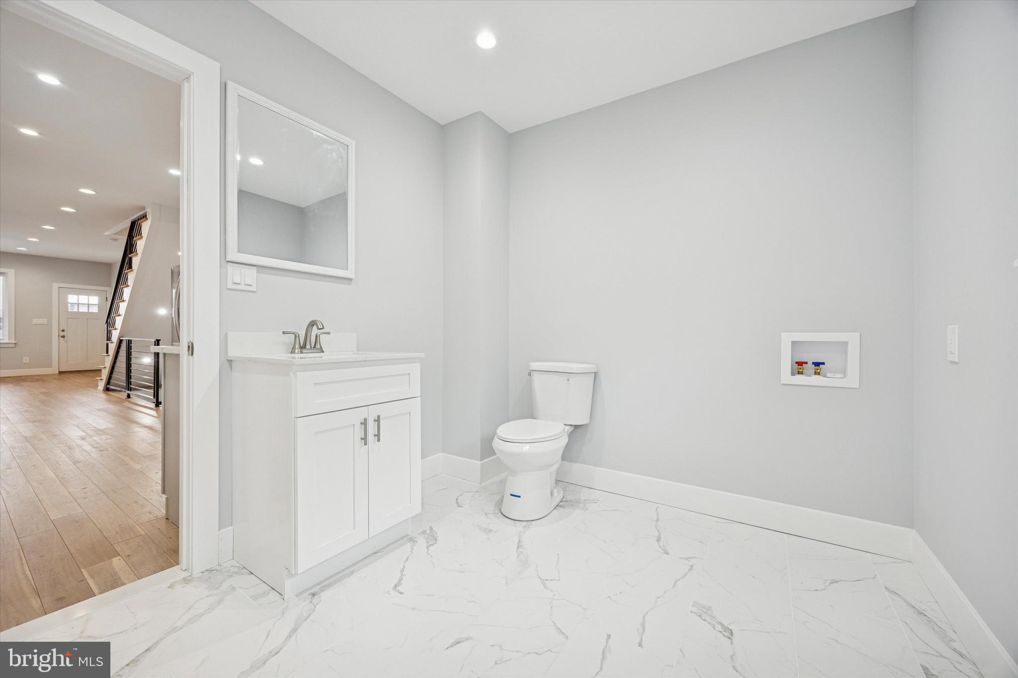2869 Aramingo Avenue Philadelphia, PA 19134 - Photo 23 of 25 a spacious bathroom with a toilet sink and mirror