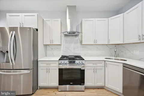 a kitchen with stainless steel appliances a stove a sink and a refrigerator