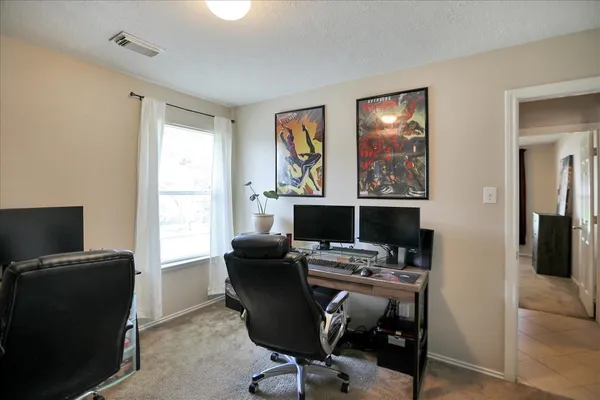 a view of a workspace with furniture and a window