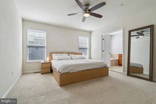 a spacious bedroom with a large bed and a chandelier
