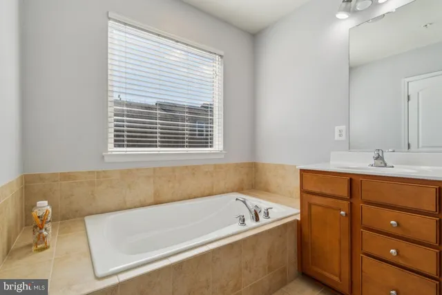 a bathroom with a tub sink and mirror
