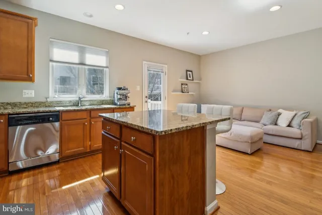 a kitchen with granite countertop a sink and a stove with wooden floor