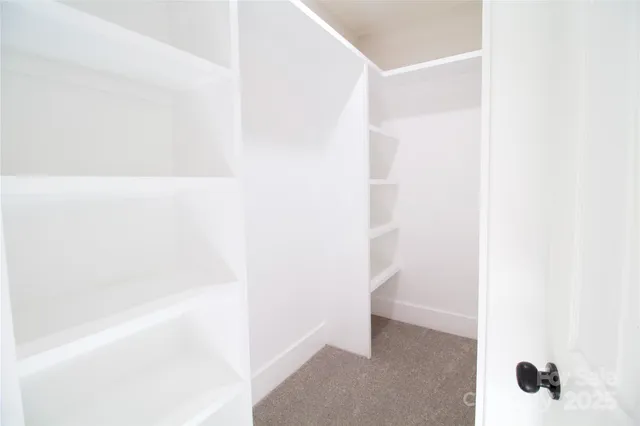 a view of a hallway with wooden floor and closet