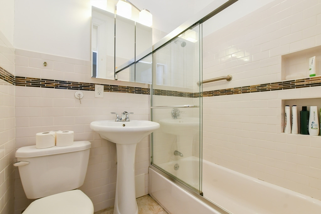 1091 Boylston Street, Unit 31 Boston, MA 02215 - Photo 12 of 14 a bathroom with a sink a mirror a toilet and a bathtub