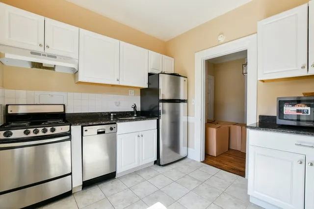 a kitchen with white cabinets and stainless steel appliances