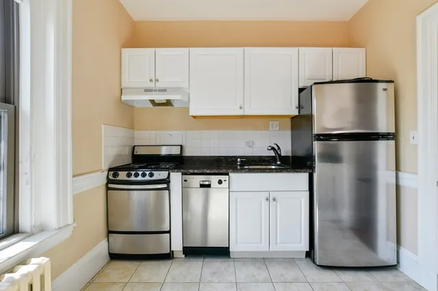 a kitchen with white cabinets and white appliances