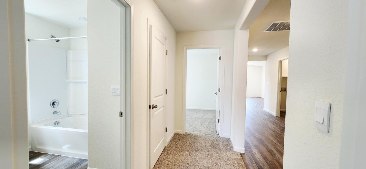 240 Teton Rnch Way Patterson, CA 95363 - Photo 12 of 13 hall featuring light carpet and light wood-style flooring