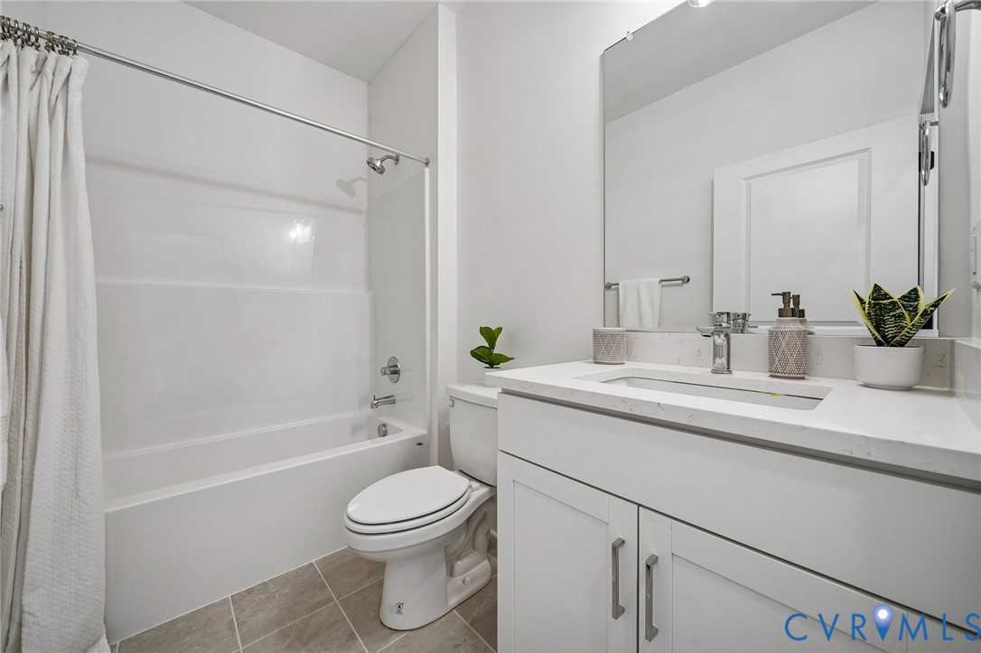 12042 Flowering Lavender Loop Henrico, VA 23233 - Photo 11 of 46 a bathroom with a sink a toilet a mirror a bathtub and shower