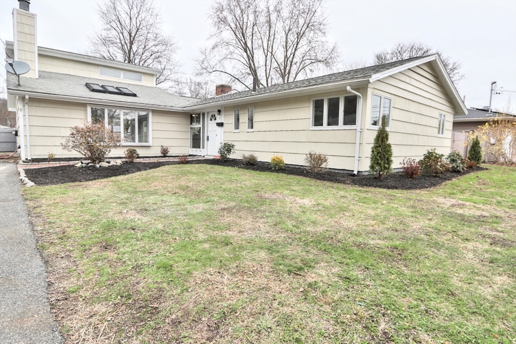 a view of a white house with a big yard and large trees