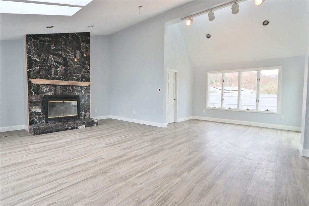 9 Poskus Road Framingham, MA 01701 - Photo 25 of 36 an empty room with wooden floor fireplace and windows