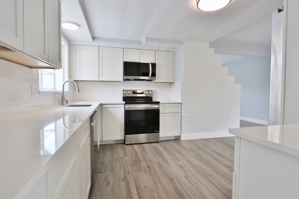 9 Poskus Road Framingham, MA 01701 - Photo 26 of 36 a kitchen with granite countertop a sink and steel appliances