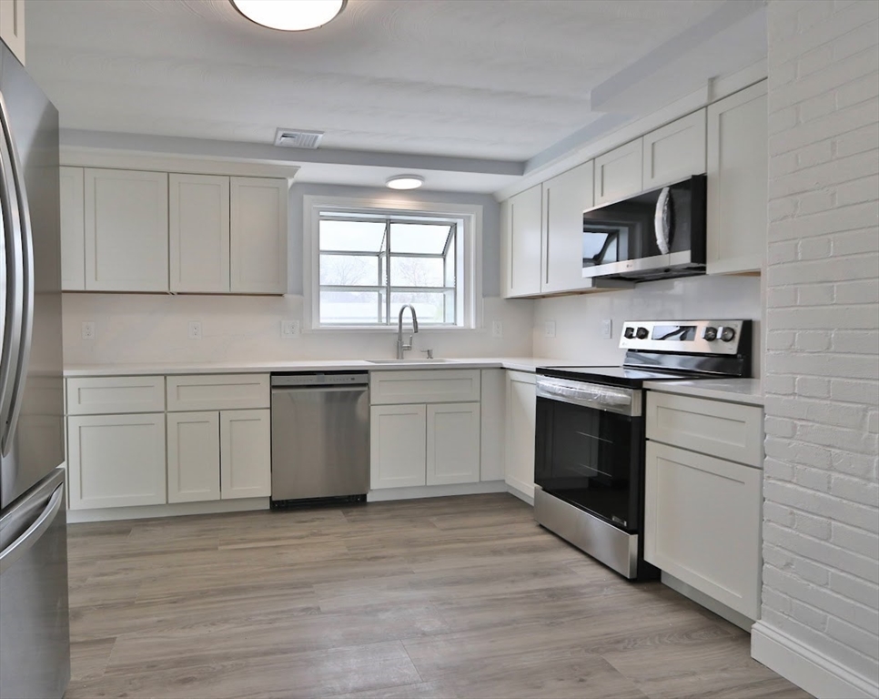 9 Poskus Road Framingham, MA 01701 - Photo 3 of 36 a kitchen with stainless steel appliances a stove a sink and a microwave