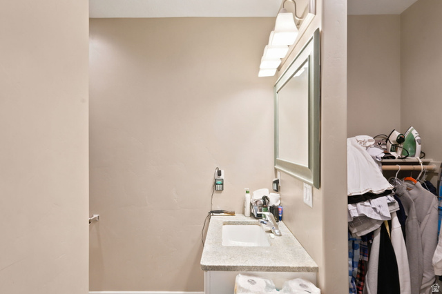 580 North 300 East Logan, UT 84321 - Photo 56 of 74 Vanity area featuring a light-toned countertop with an integrated sink, a large framed mirror, and a five-light fixture