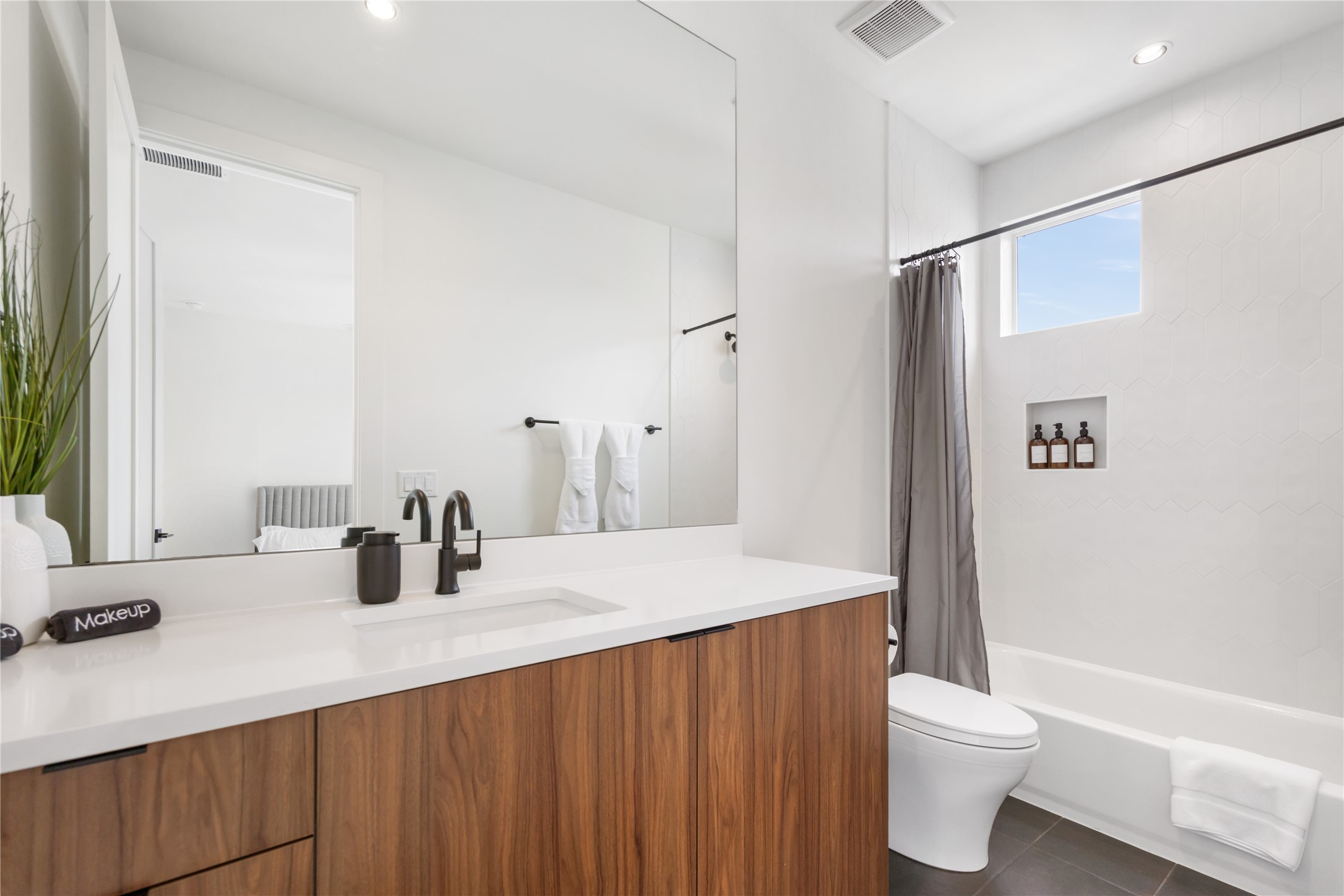 3201 Holton Street Austin, TX 78702 - Photo 25 of 39 Each secondary bedroom features a private ensuite bathroom equipped with rich wood-toned vanities, modern matte black fixtures, and clean, contemporary tiling.
