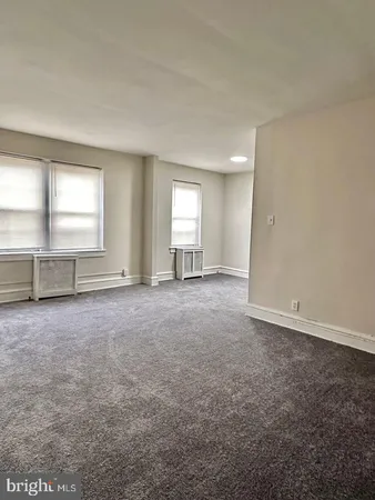 an empty room with windows and closet