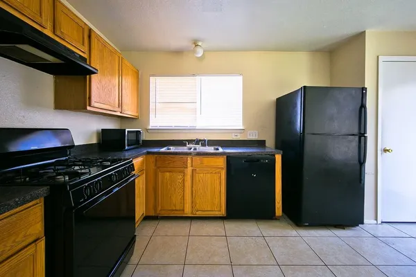 a kitchen with a refrigerator a stove and a window