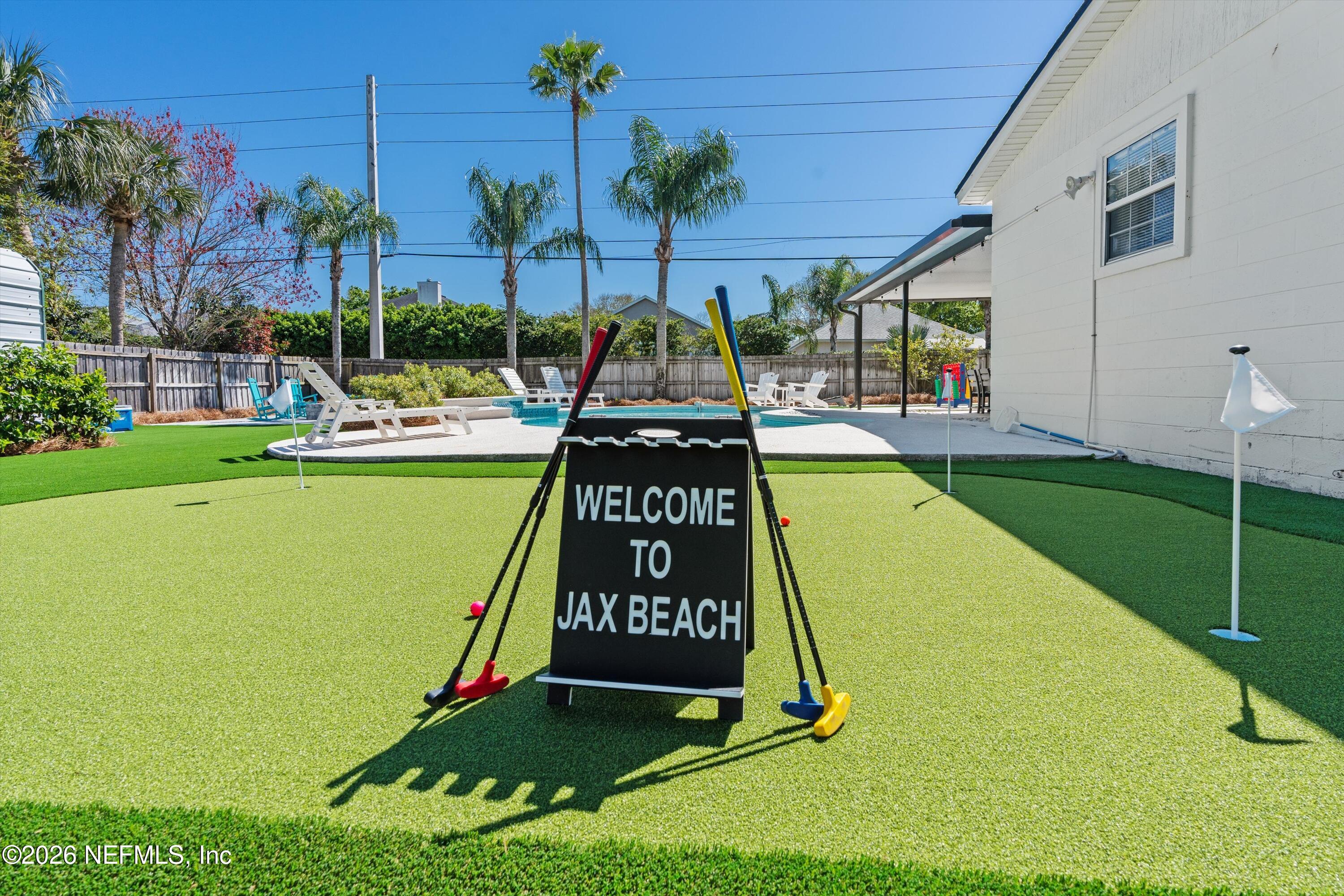 31 Norberta Way Jacksonville Beach, FL 32250 - Photo 2 of 49 a view of a swimming pool with a garden and trees