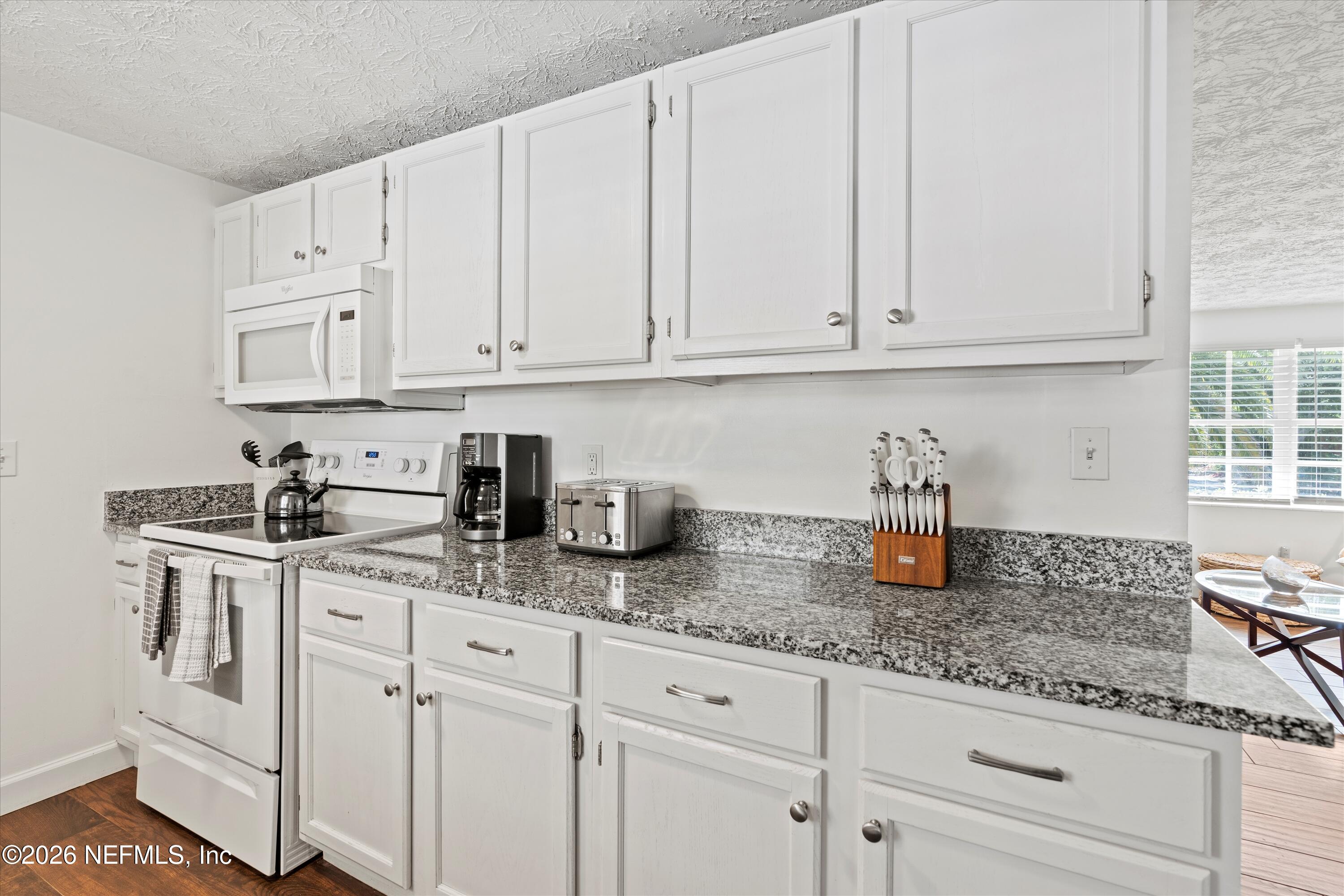 31 Norberta Way Jacksonville Beach, FL 32250 - Photo 32 of 49 a kitchen with granite countertop white cabinets and white appliances