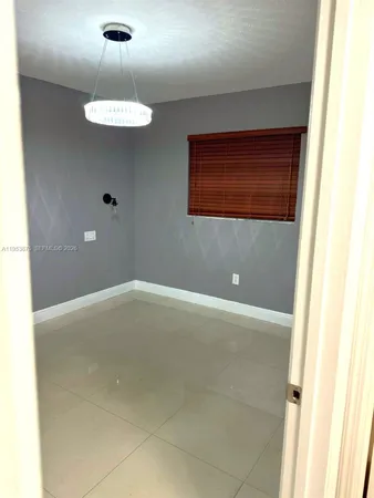 a view of an empty room with a chandelier fan
