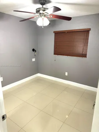 a view of a room with a ceiling fan and carpet