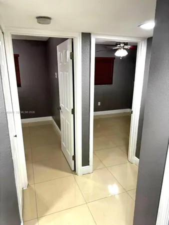a view of an empty room with a chandelier fan