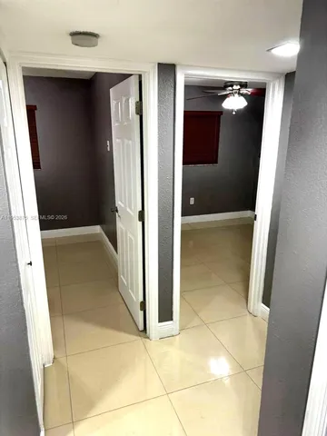a view of an empty room with a chandelier fan
