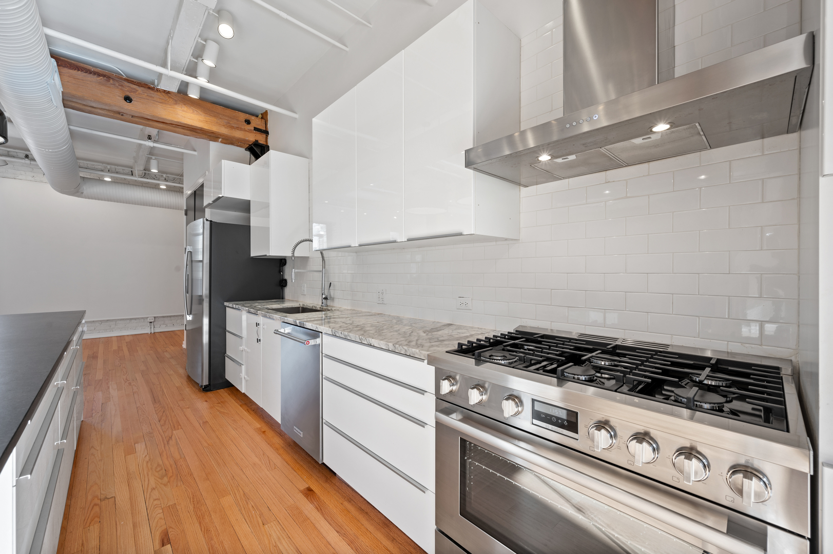 900 West Jackson Boulevard, Unit 3W Chicago, IL 60607 - Photo 11 of 38 a kitchen with granite countertop a stove and a wooden floor