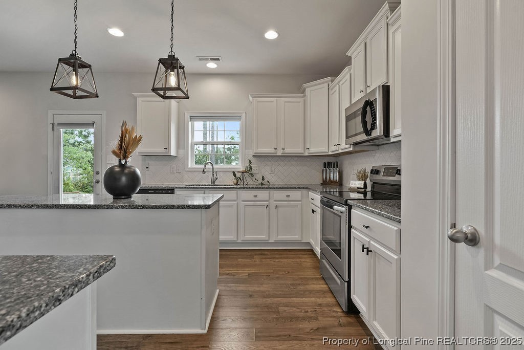 150 Timber Skip Drive Spring Lake, NC 28390 - Photo 14 of 39 a kitchen with stainless steel appliances granite countertop a sink a stove and cabinets