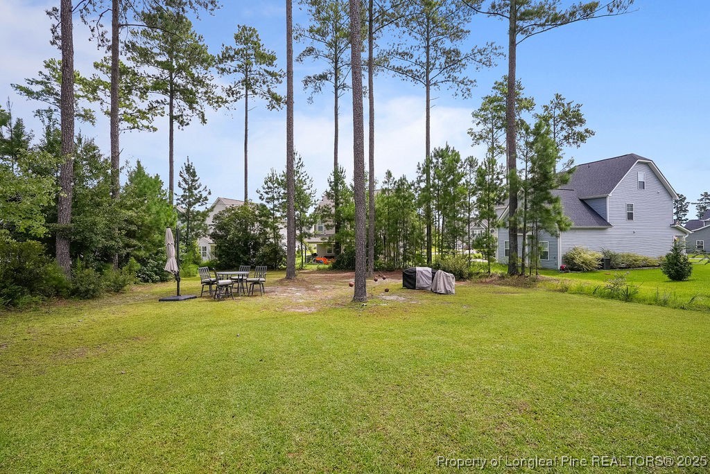 150 Timber Skip Drive Spring Lake, NC 28390 - Photo 38 of 39 a view of a swimming pool with lawn chairs and plants
