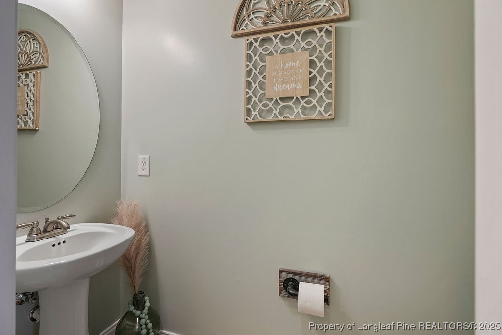150 Timber Skip Drive Spring Lake, NC 28390 - Photo 8 of 39 a bathroom with a sink and mirror with toilet