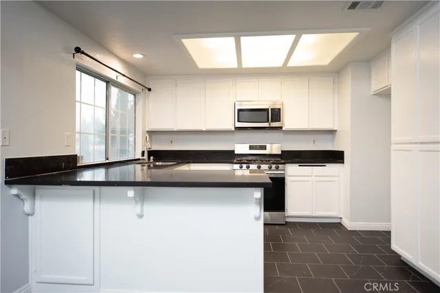 a kitchen with stainless steel appliances a sink stove and microwave