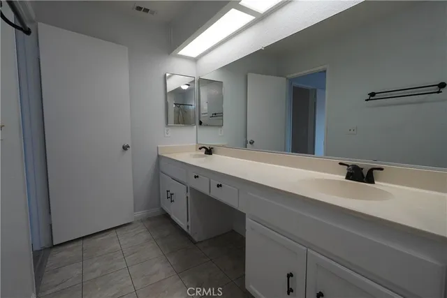 a spacious bathroom with a double vanity sink and mirror
