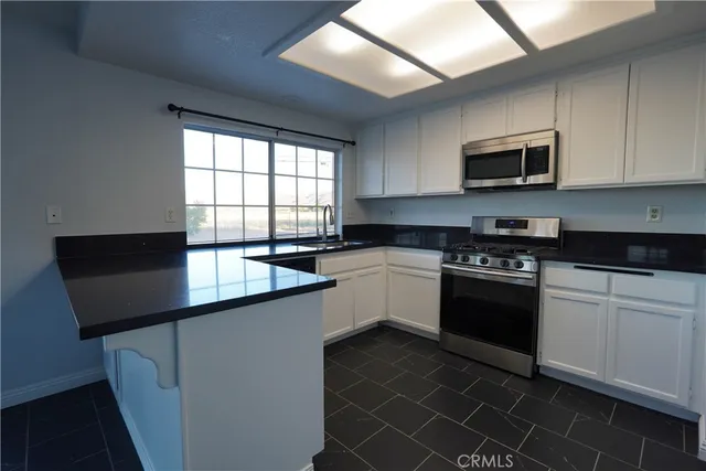 a kitchen with stainless steel appliances a sink stove and microwave