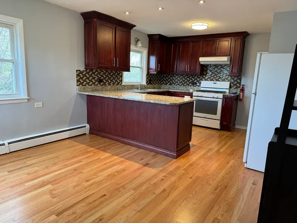 a kitchen with stainless steel appliances granite countertop a stove a sink and a refrigerator