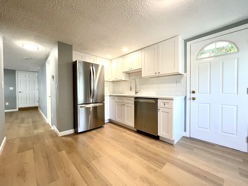 46-52 Main Street, Unit 2R Framingham, MA 01702 - Photo 2 of 7 a kitchen with stainless steel appliances a refrigerator and a stove top oven