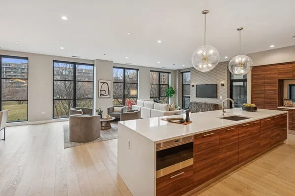 a large kitchen with stainless steel appliances kitchen island granite countertop a large counter a stove and a sink