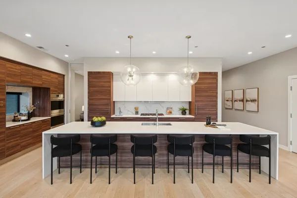 a kitchen with a dining table chairs and white cabinets