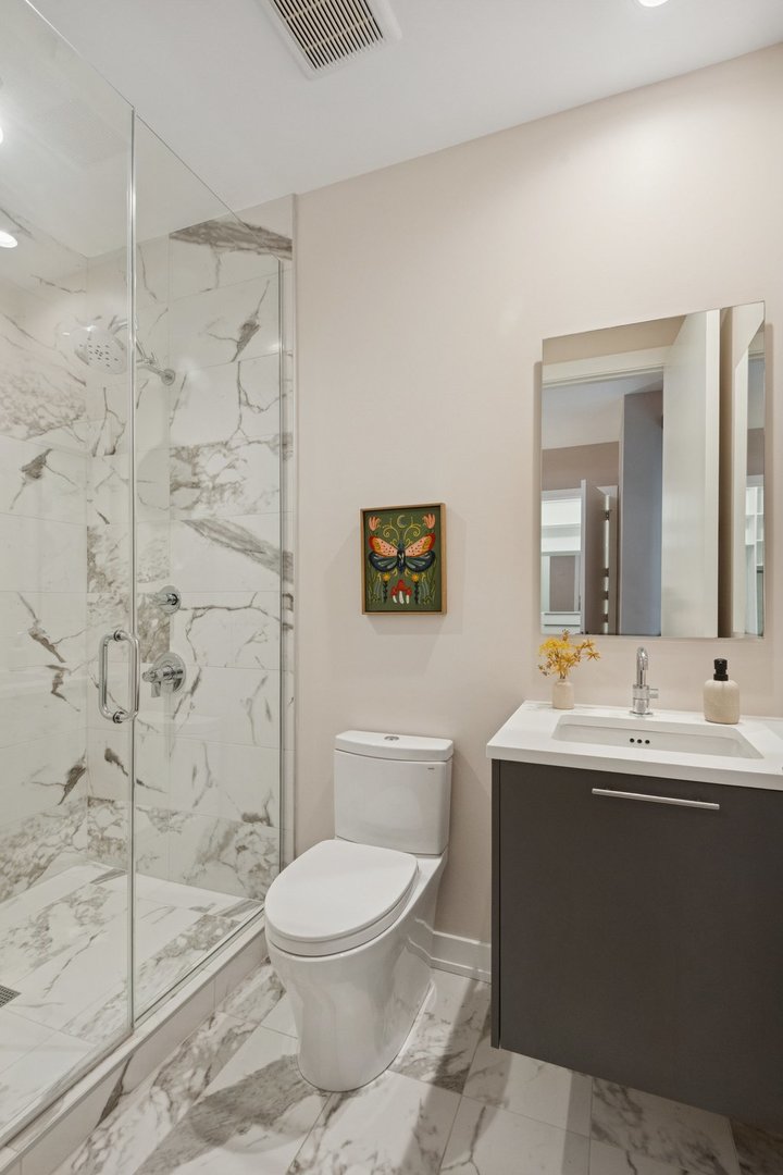 123 South Peoria Street, Unit P2 Chicago, IL 60607 - Photo 34 of 50 a bathroom with a toilet a sink a mirror a shower a window and vanity