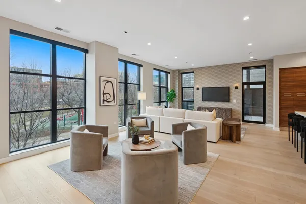 a living room with couches a flat tv and a dining table with wooden floor