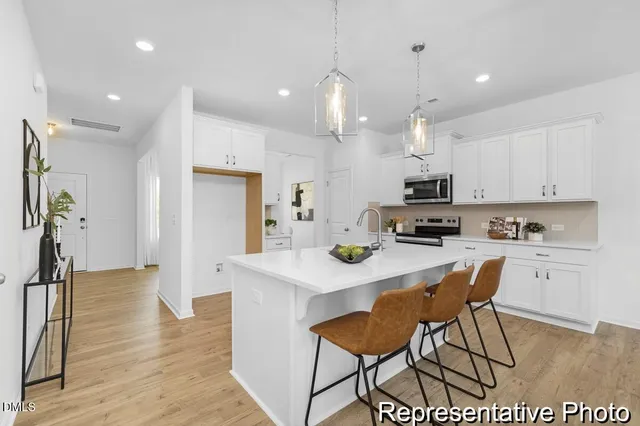 a kitchen with kitchen island a stove a table and chairs in it