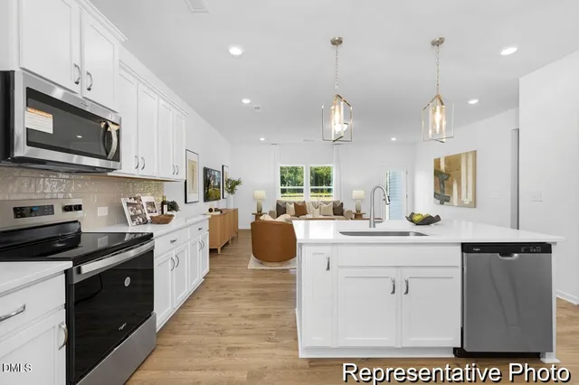 a kitchen with stainless steel appliances kitchen island granite countertop a sink a stove and cabinets