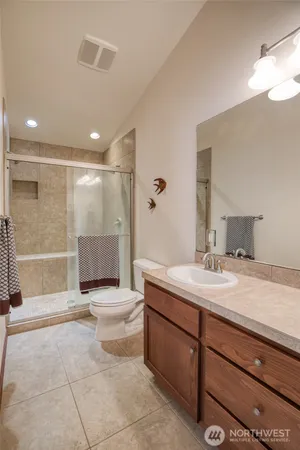 a spacious bathroom with a granite countertop sink a toilet and a mirror