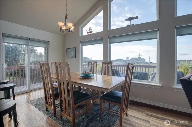 a dining room with furniture large windows and wooden floor